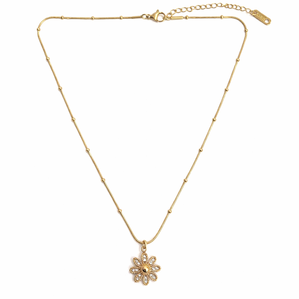 Top view of floral pendant necklace styled on a clean background